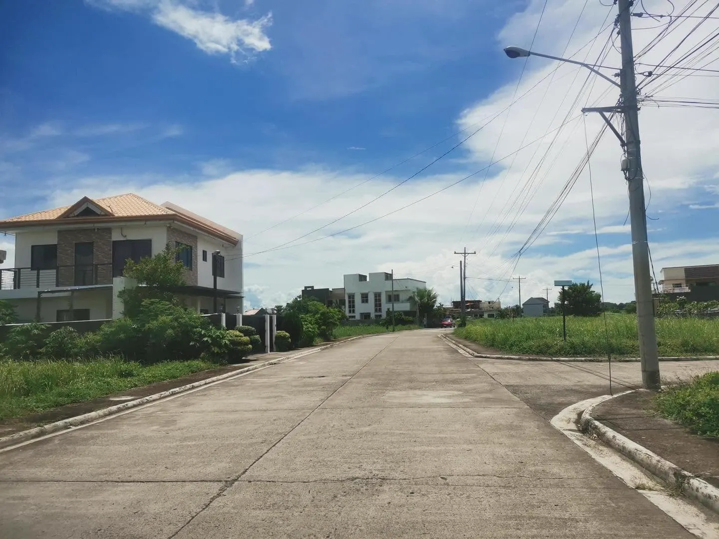 Subdivision street inside a San Antonio Resort Village development, two storey house on the left under a clear blue sky