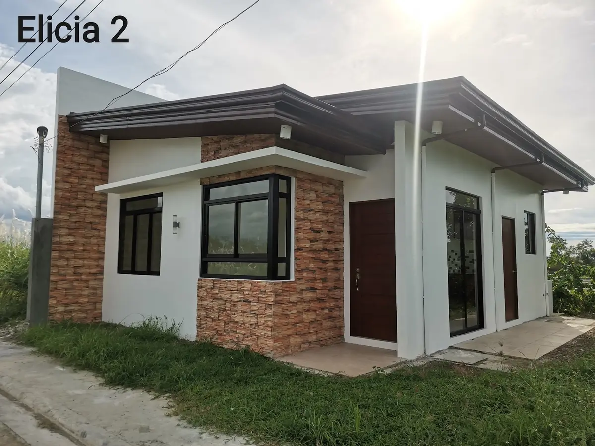 Elicia 2 exterior, white bungalow with stone clad accents, bay window, and dark wood front door