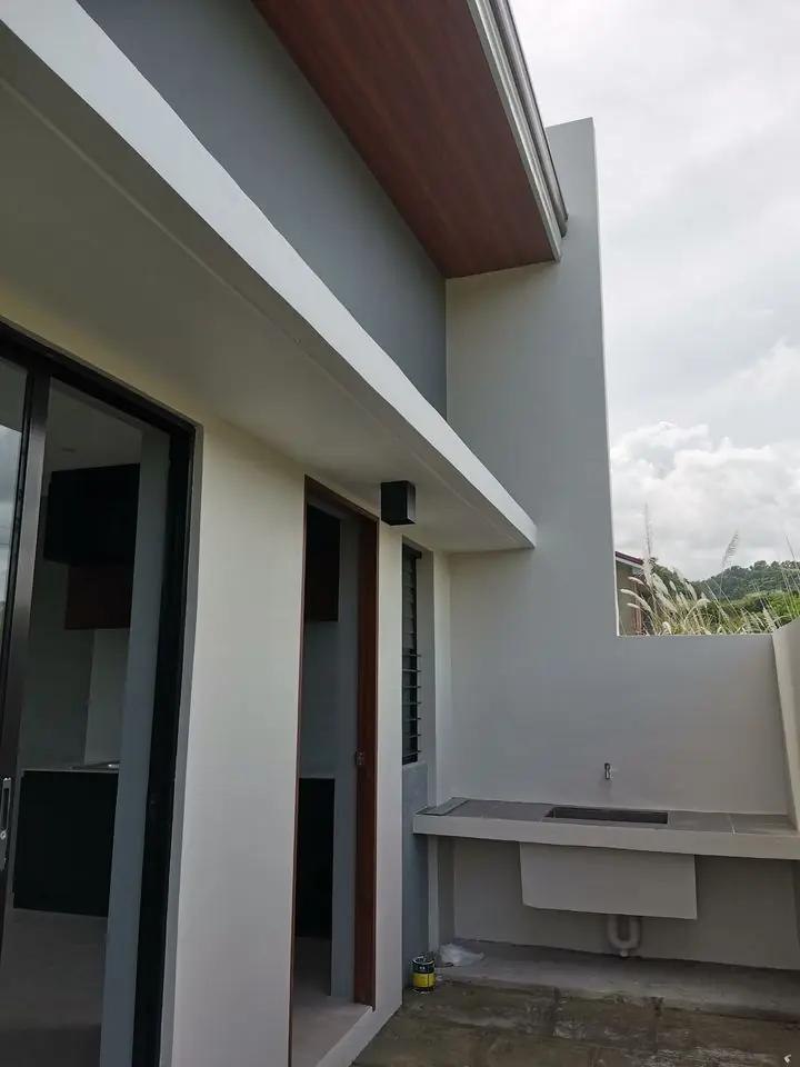Side yard with a concrete utility counter and sink against a wall, beside sliding glass doors