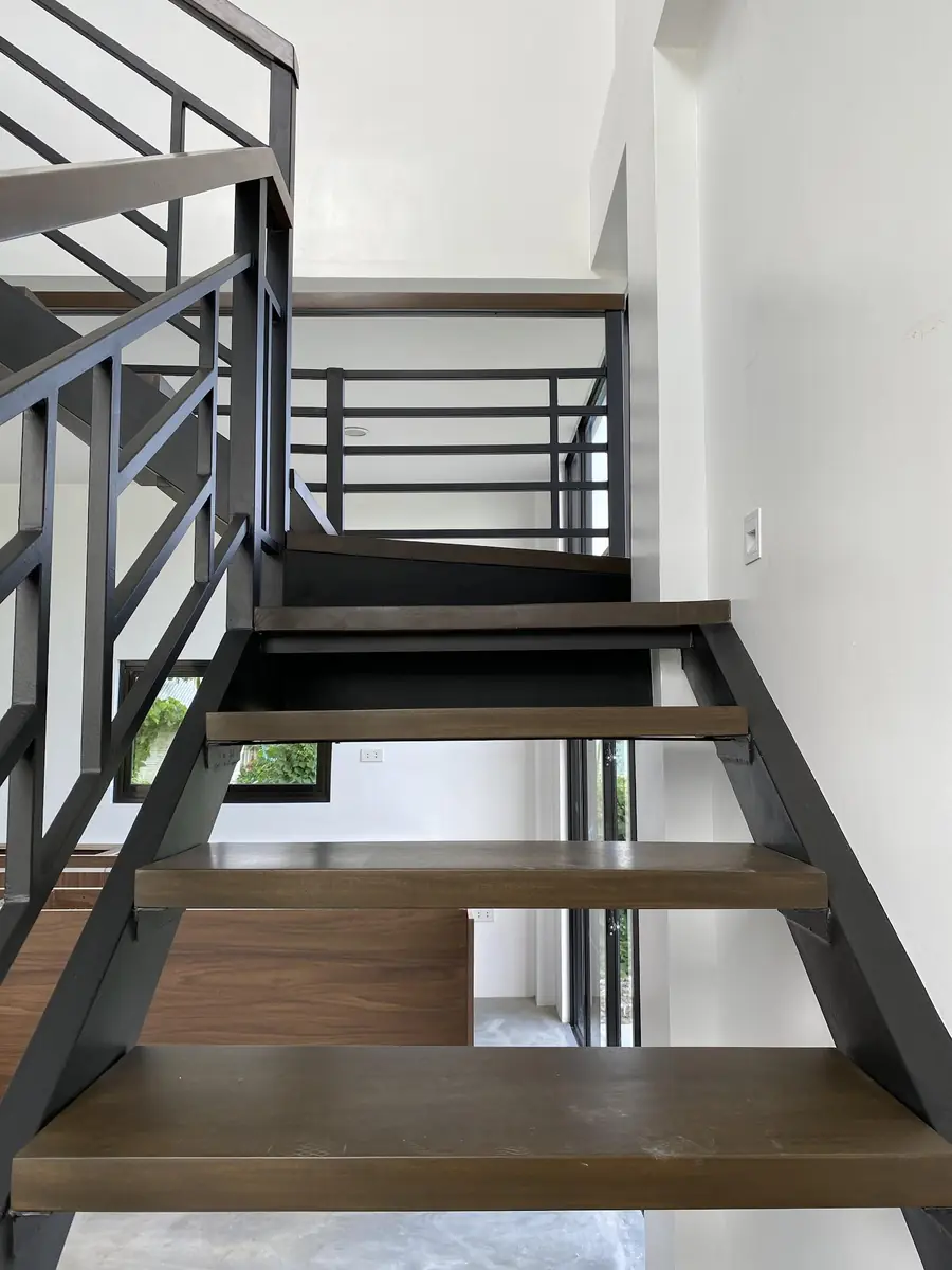 Open riser staircase with wood treads and black steel stringers and railings